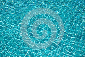 Background of rippled pattern of clean water in a blue swimming pool