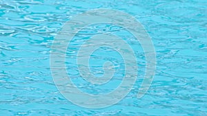 Background of rippled pattern of clean water in blue swimming pool. Summer holiday.