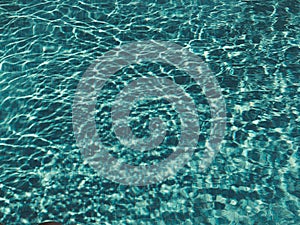 Background of rippled pattern of clean water in a blue swimming pool