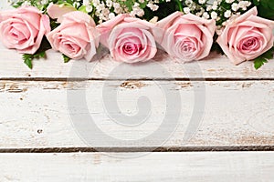 Background with rose flowers on wooden table