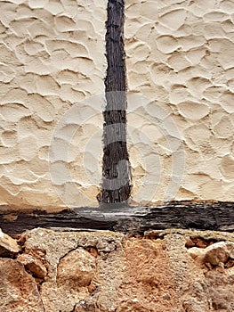 Background of rough wall made of white cement, black wooden slat and limestone. Detail of beams, lumber and other construction