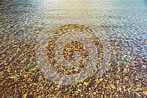 Background of a round stone pebbles on the bottom of the lake under water