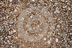 Background Sea pebbles and sand on the beach, texture close-up.