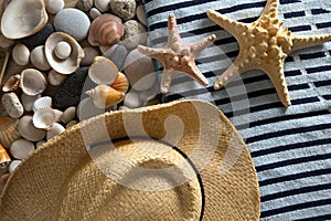 Background with sea stones, seashells, hat and beach towel