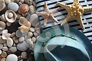 Background with sea stones, seashells, hat and beach towel