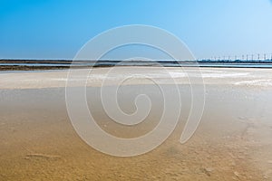 Background of sea water prepare in the salt field to let it dry from sun with blue sky in Thailand, The crystallization of