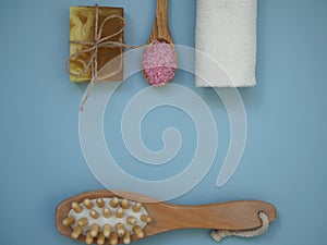 Background with a set of items for spa body skin care treatments on a blue background with space for text. Body massager