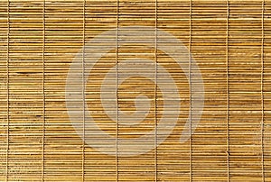 Background shot of a texture of a bamboo sun shade rolled down. Wooden blinds