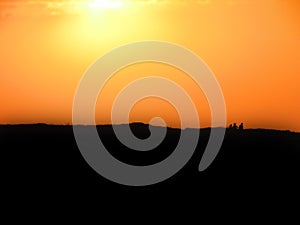 Background of silhouetted grass with sky orange at sunset on Habonim Israel