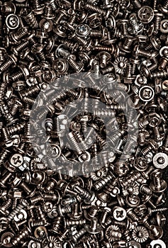 A background of silver screws and bolts. Various screws. Hardware