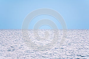 Background of sky and sea, sea is very calm with gentle ripples, sky perfectly clear