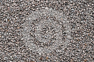 Background of small brown and gray pebbles. Rough stone wall, abstract pattern. Surface, rock texture.