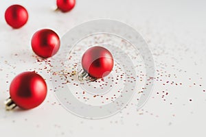 Background with small red Christmas balls and colorful confetti