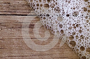 Background of soap foam and water bubbles on wood, macro