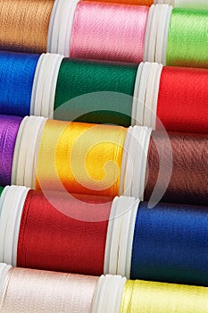 Background from spools with multi-colored sewing threads, photo stacking