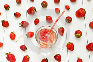 Background from strawberry water and fresh berries on a white table. Summer drink