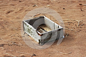 Background of summer beach with empty wooden ammunition box after high tide and low tide.