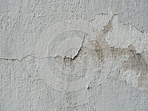 Background, surface texture. a layer of white peeling paint on rough gray concrete, cement, plastered wall.