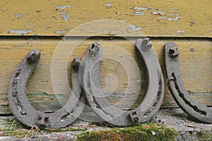 Background surface of very old and rusty horseshoes placed near the wall