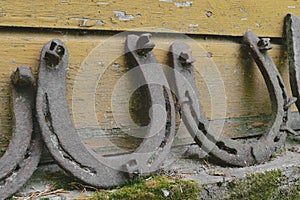 Background surface of very old and rusty horseshoes placed near the wall