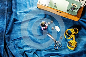 Background table top view of sewing tool and jeans on denim fabric