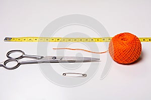 Background for tailor orange thread, measuring tape and scissors