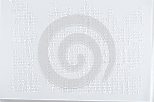 Background of text in international braille code on white paper.