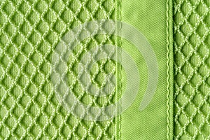 Background of textile mesh over cotton jersey. Macro. Texture of light green knitted fabric with mesh for outerwear casual