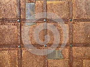 Background texture: ancient metal door. Rusty surface of a medieval door. Entrance gate to the ancient castle