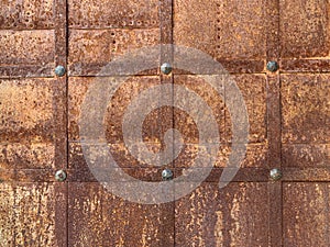 Background texture: ancient metal door. Rusty surface of a medieval door. Entrance gate to the ancient castle