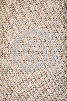 Background texture of beige pattern knitted fabric made of cotton or wool top view