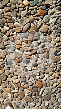 Background texture brown pebbles  in a concrete wall