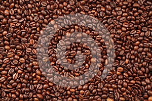 Background texture of evenly roasted coffee beans, top view