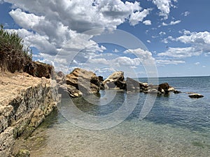 Background texture: large stones of various shapes in the sea. A pile of granite boulders against the background of the sea and