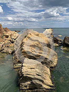 Background texture: large stones of various shapes in the sea. A pile of granite boulders against the background of the sea and