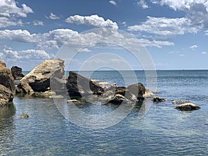 Background texture: large stones of various shapes in the sea. A pile of granite boulders against the background of the sea and