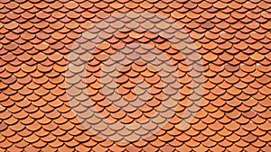 Background and texture of orange imbrication clay tiles roof of Thai temple