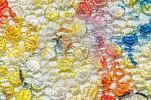 Background texture; pattern. Cloth with glued lace stripes. Multicolored lace with sparkles; cording and metallic embroidery. photo