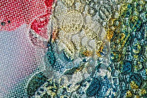 Background texture; pattern. Cloth with glued lace stripes. Multicolored lace with sparkles; cording and metallic embroidery. photo