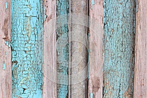 Background texture pattern of weathered wooden planks with grungy remnants of blue paint forming the siding of an exterior buildin