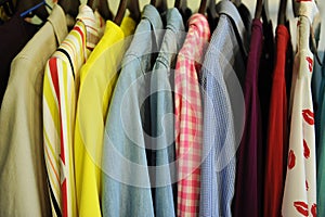 Background texture from a row of colored shirts and blouses on a hanger