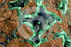 Background, texture: surface of a block of copper ore with veins and geodes of malachite