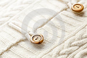 Background texture of white pattern knitted fabric made of cotton or wool and wooden button