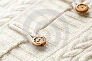 Background texture of white pattern knitted fabric made of cotton or wool and wooden button