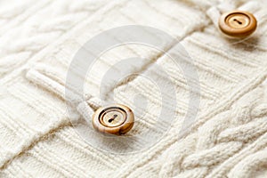 Background texture of white pattern knitted fabric made of cotton or wool and wooden button