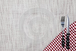 The background to create the restaurant`s menu. Linen tablecloth fork knife on a bright checkered cloth. Is used to create a menu