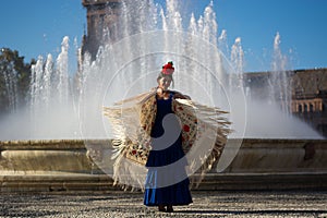 The happy woman dancing flamenco near the fountain