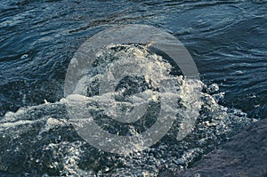 Background, top view, rapid flow river with dark blue water and white foam waves