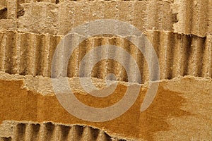 Background from torn corrugated cardboard. Brown background of torn cardboard texture with wavy pattern