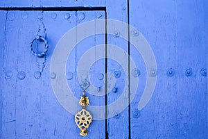 Background of traditional powder blue painted door with golde doorknocker